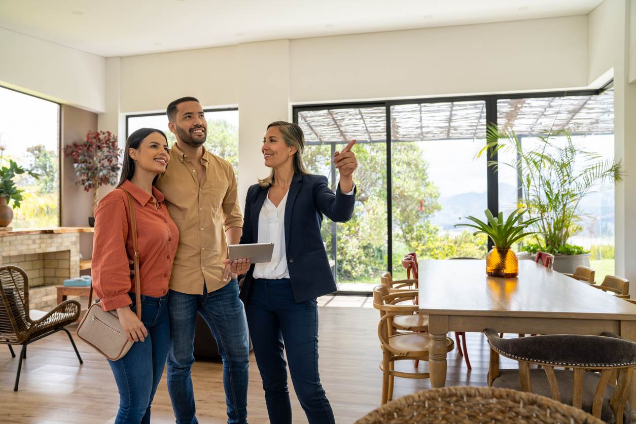 A real estate agent showing a couple a home