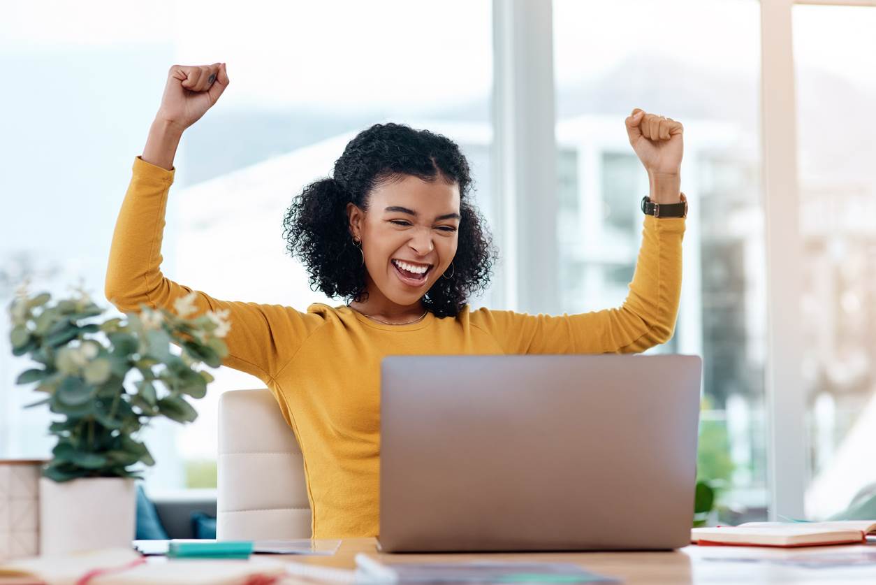 Young woman with her arms up in the air valiantly