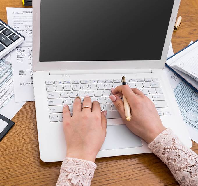 Hands typing on a laptop keyboard