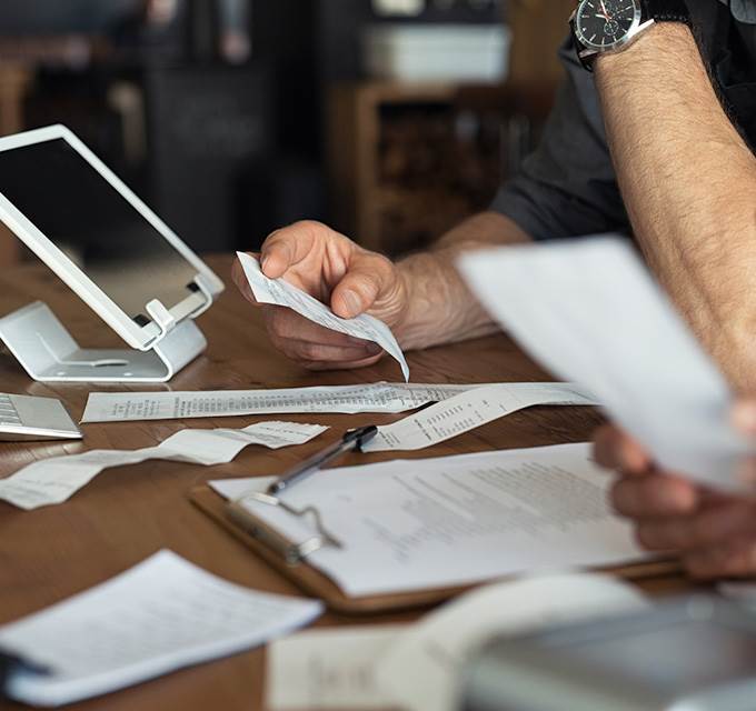 A person at a desk looking at a receipt